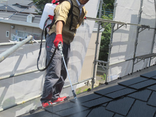 屋根をバイオ洗浄剤散布中